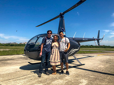 A family posing in front of a helicopter.